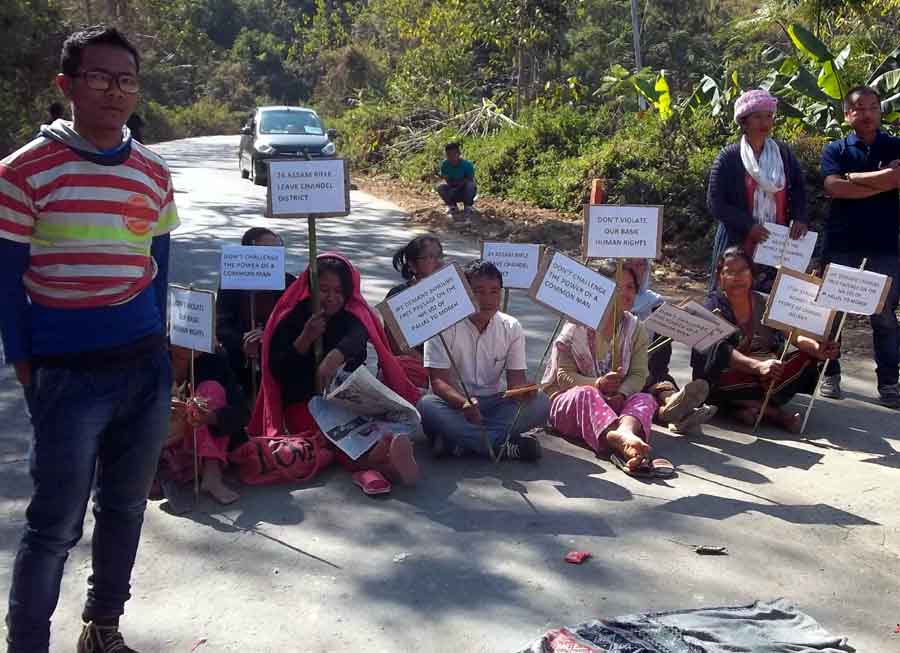 A boy stands in front of women bandh supporters seen holding placards along the Imphal-Moreh highway.