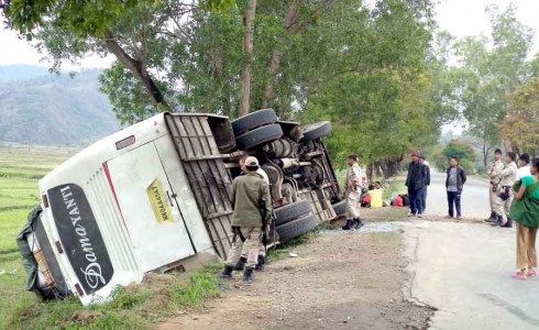 The bus lying overturned at the roadside.