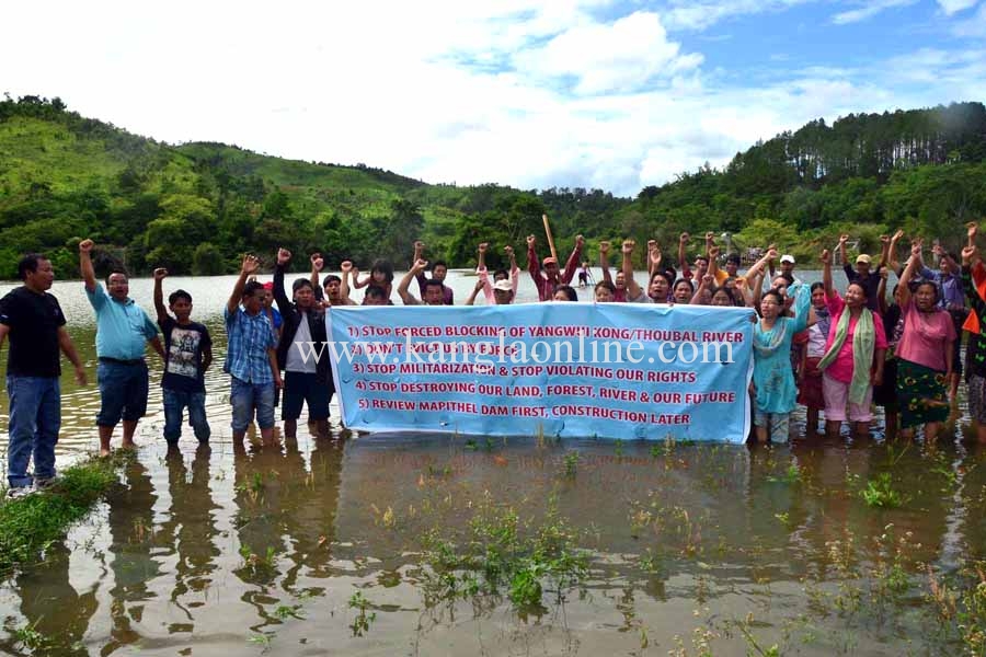 Villagers posed behind a banner demanding review of Mapithel Dam before its construction.