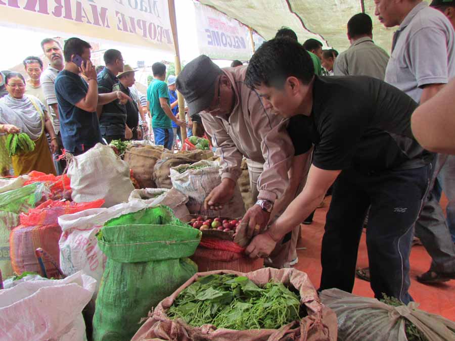 People checking the vegetables and fruits at the temporary market for Mao vendors.