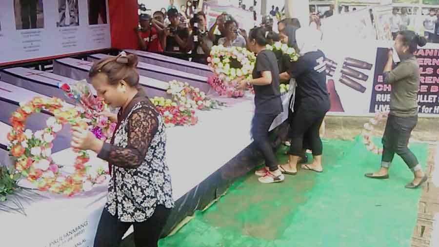 People offering floral wreaths at the symbolic coffins of the Ccpur martyrs.