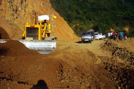 Vehicles wait while a bulldozer levels the road near Tengnoupal along the Imphal-Moreh highway.