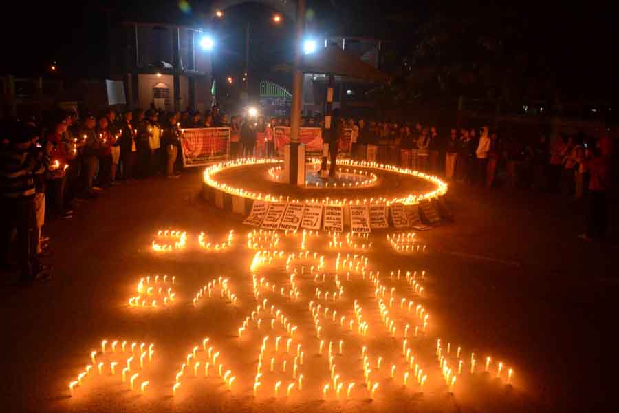 Students of Manipur University under the aegis of NEFIS taking out a candle light vigil up to the university main gate.